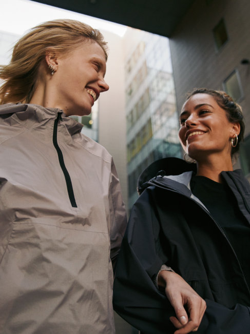Zwei Frauen spazieren lächelnd durch die Stadt