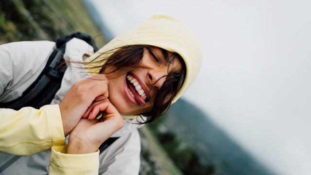 Eine Frau und ein Mann in sommerlicher Wanderkleidung klettern einen Felsen hinauf