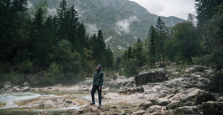 Mann in Outdoorkleidung steht in nebeliger Berglandschaft