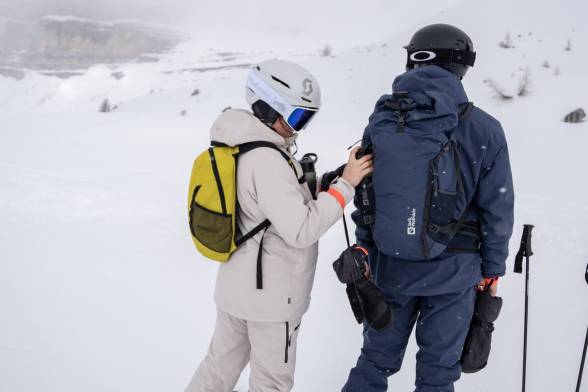 Woman and man in ski clothing in a snowy mountain landscape