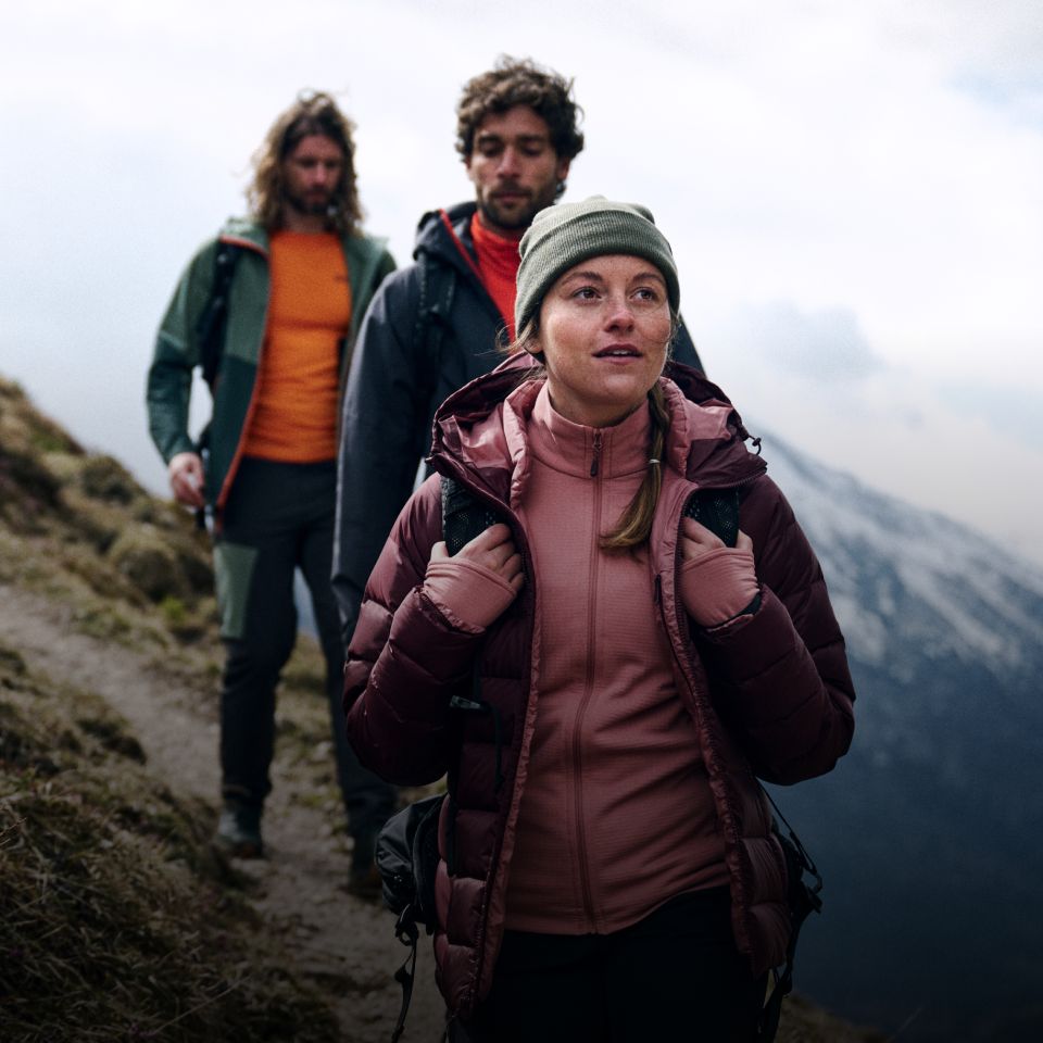 Drei Wanderer in warmer Kleidung wandern auf einem Berg